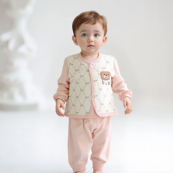 Baby wearing a pink outfit with a bib and pants on a white background