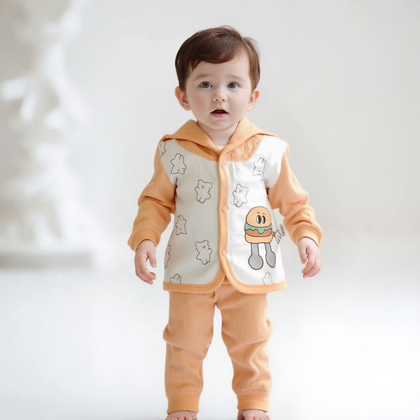 Baby wearing an orange outfit with cartoon designs on a white background