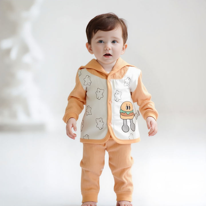 Baby wearing an orange outfit with cartoon designs on a white background
