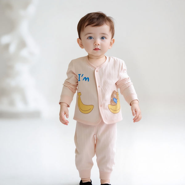 Baby wearing a light pink outfit with banana designs and text on a white background