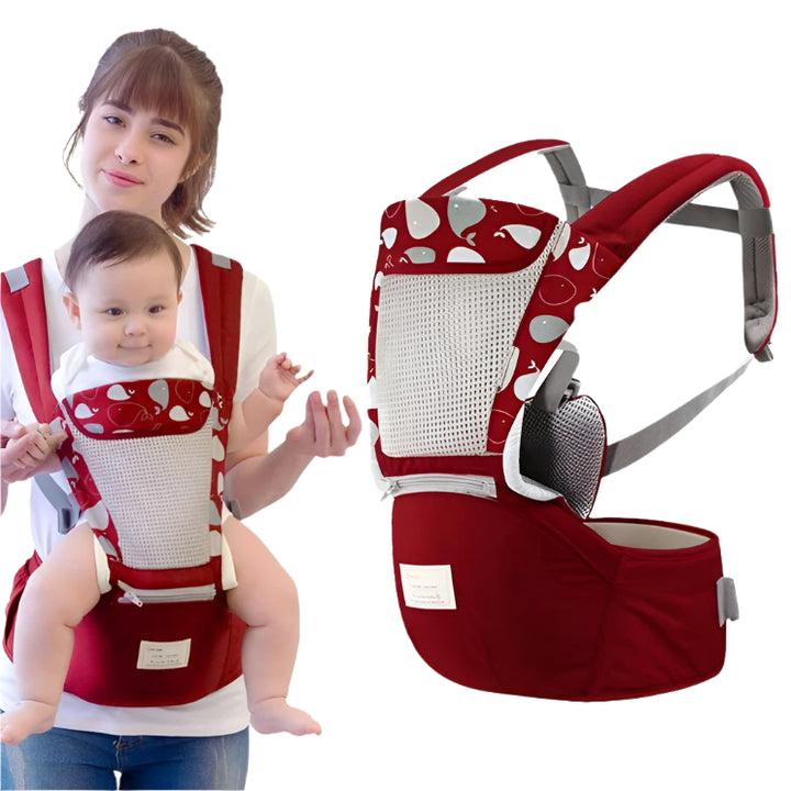 Red baby carrier with white polka dots worn by a woman, with 'Kids Unlimited' branding.